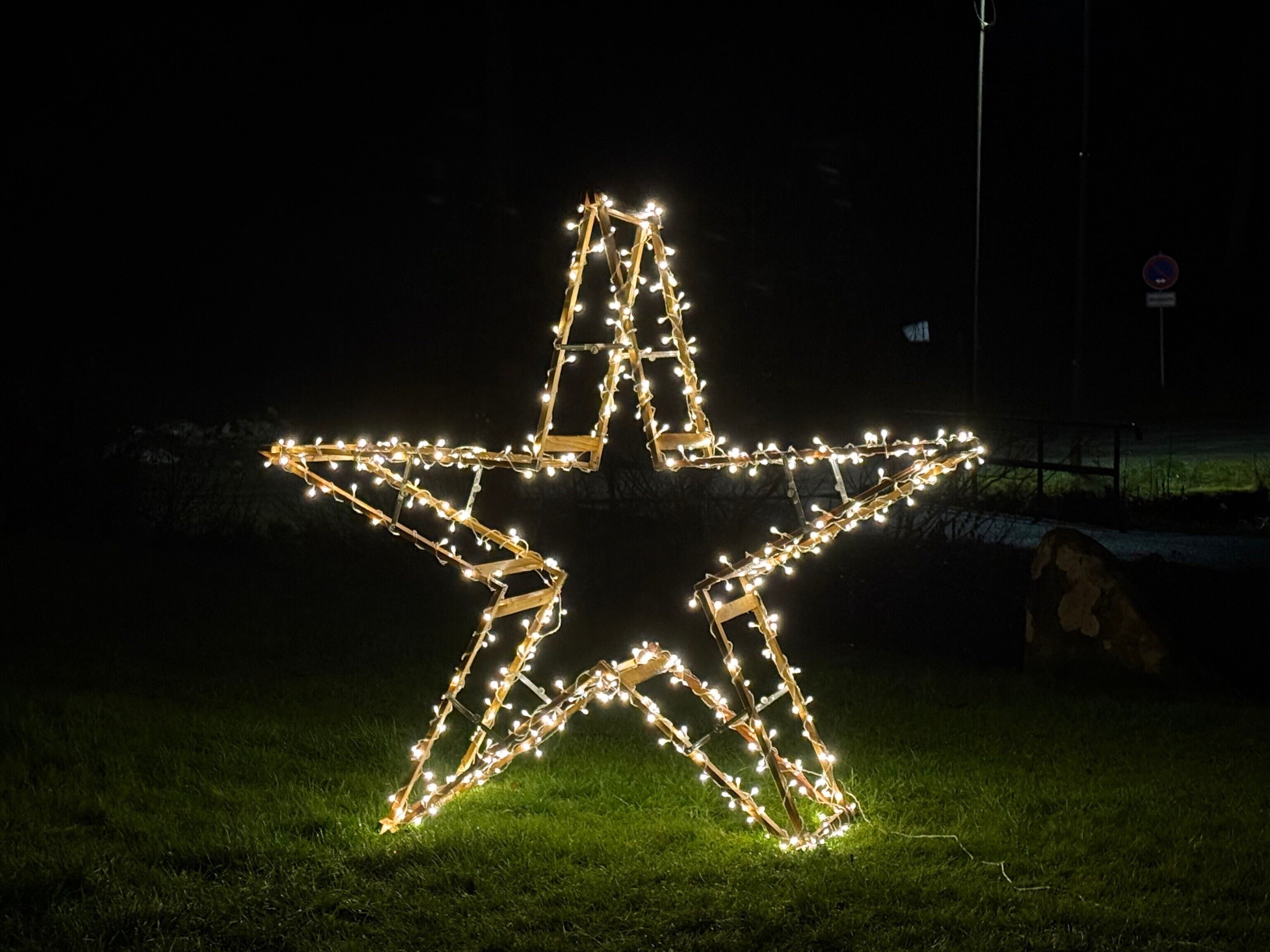 Installazione luminosa a forma di stella su un prato.