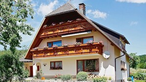 A two-story chalet with wooden balconies, a sloped roof, and a satellite dish. - Apartment 'Mit Terasse 110qm' with Mountain View, Private Terrace and Wi-Fi (Schluchsee)