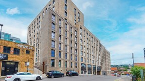 A multi-story building with a prominent corner entrance, large windows, and a visible sign for 'FROZE'. - 2 Bedroom Duplex Apartment (Sheffield)