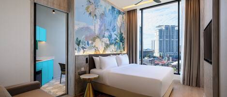 A hotel room with a bed, a desk, a chair, a round table, and a large window with a city view.