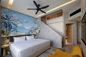 A modern bedroom with a large bed, a ceiling fan, and a mural of tropical scenery. - Fifth Avenue Hotel (George Town)