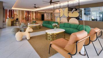 A modern lounge area with leather sofas, a round coffee table, and a unique ceiling design.