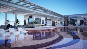 A modern hotel lobby with a pool, seating areas, and a reception desk. - Fifth Avenue Hotel (George Town)