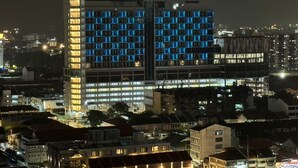 A high-rise building with multiple floors, featuring a modern architectural design with illuminated windows. - Fifth Avenue Hotel (George Town)