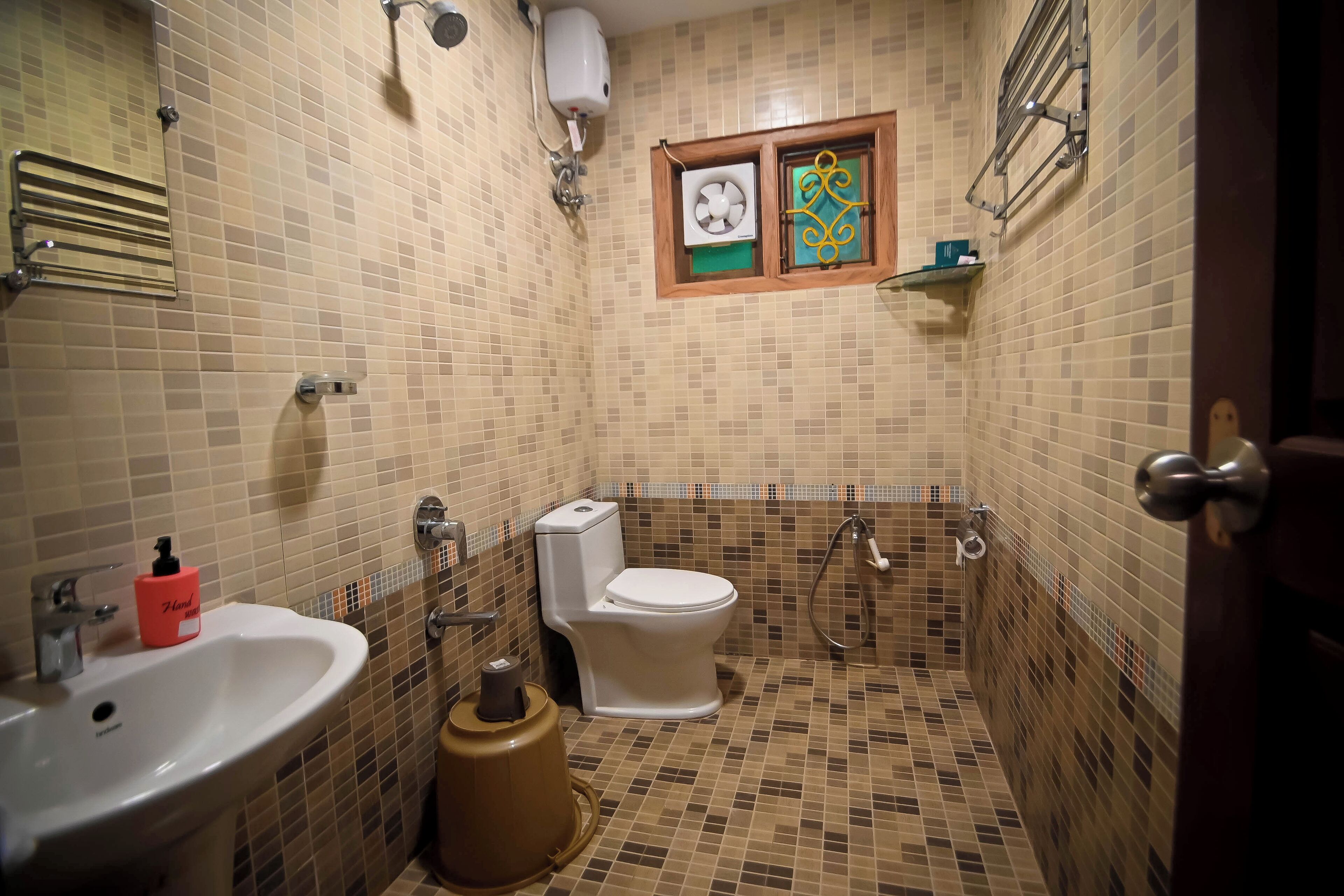 A small bathroom with a sink, toilet, and shower.