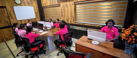 A conference room with wooden paneling, a whiteboard, and a clock on the wall.