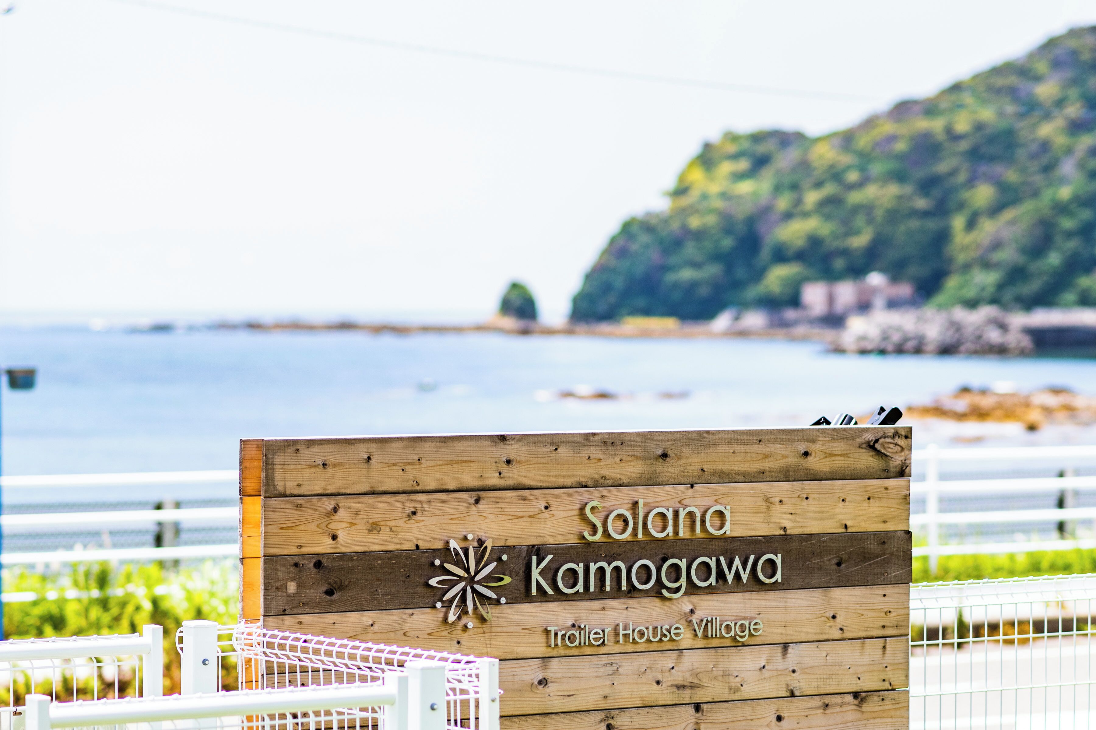 Un letrero de madera con la inscripción 'Solana Kamogawa Trailer House Village'.