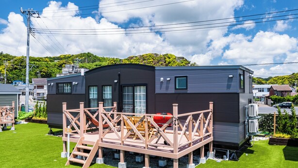 A modern mobile home with a deck, surrounded by green grass and a clear sky. - Solana Kamogawa (Kamogawa)