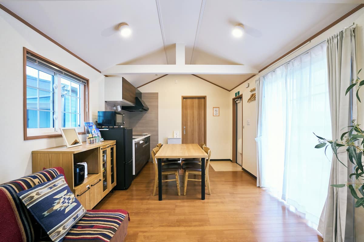 Cocina compacta con una mesa de comedor, un sofá y un refrigerador.