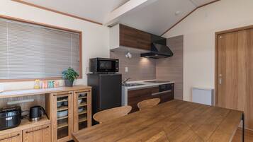 Une cuisine moderne avec une table à manger, des appareils électroménagers intégrés et des meubles de rangement en bois.