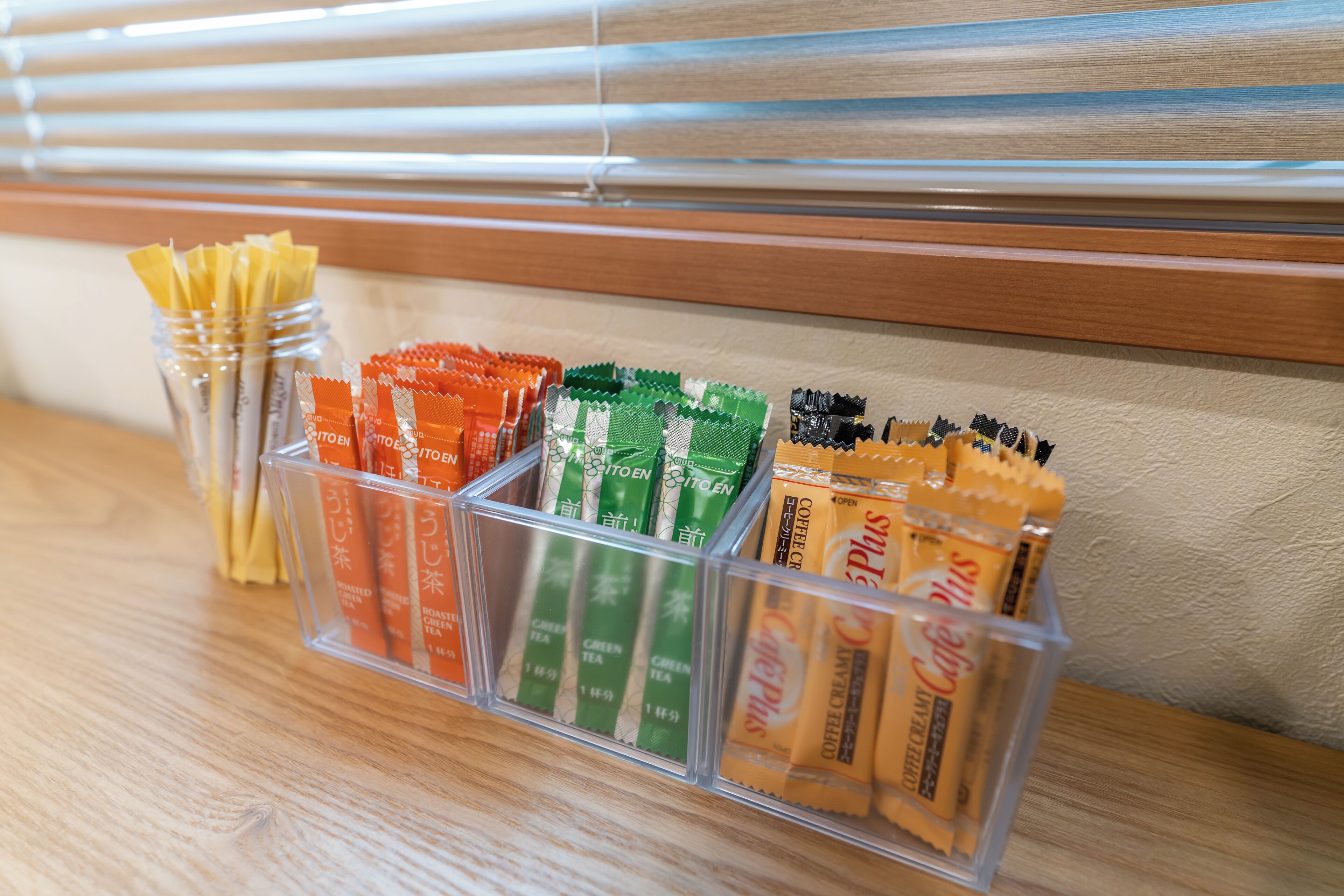 A clear plastic storage organizer with compartments containing various tea and coffee packets.