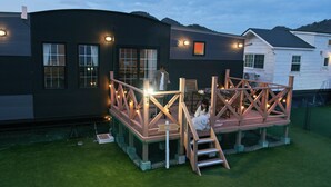 A house with a deck, a staircase, and a sign that says 'FELIZ.' - Solana Kamogawa (Kamogawa)