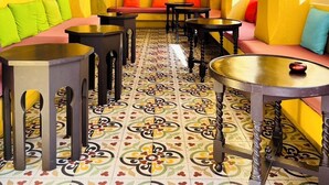 A vibrant interior with a patterned floor, a large decorative wall, and a chandelier. - Le Bush (Pattaya)