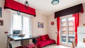 Un espacio habitable compacto con kitchenette, comedor y sofá.