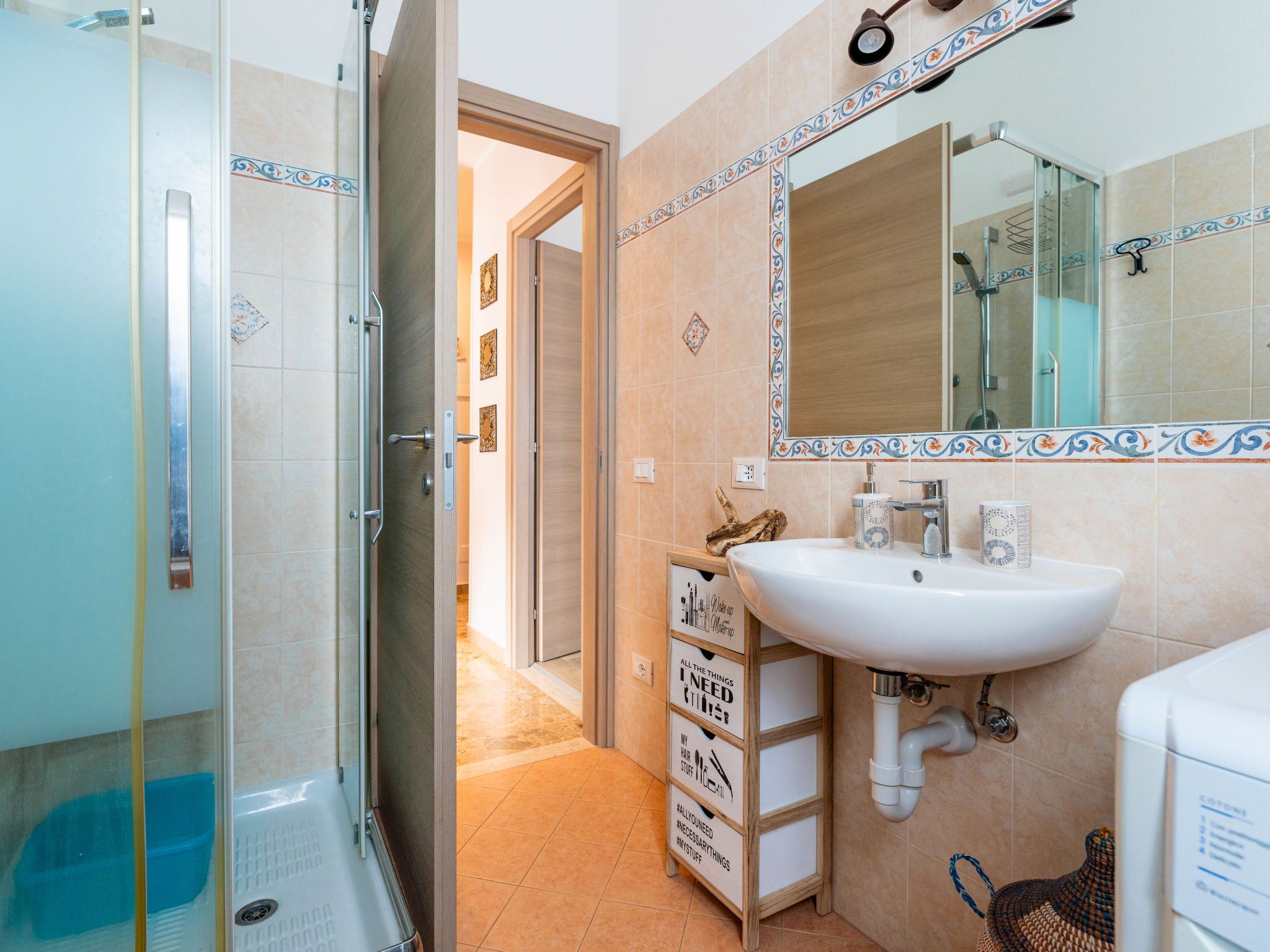 Un bagno con doccia, lavandino e specchio.