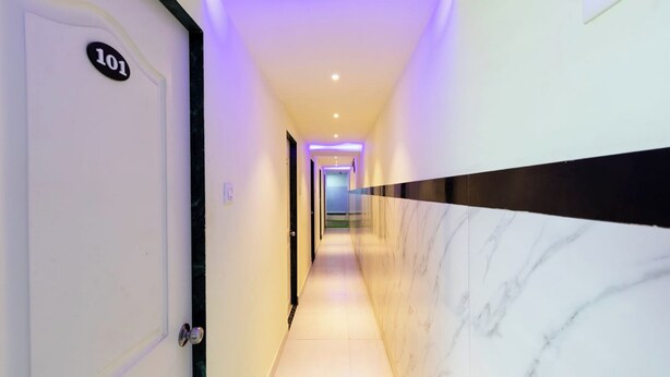 A hallway with a marble wall, a door labeled '101', and a light strip along the ceiling. - Hotel Shera Residency (Mumbai)