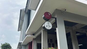 A building with a modern architectural style, featuring a covered entrance area with signage for 'The Cluster Harris' and 'Pi-tro cafe'.