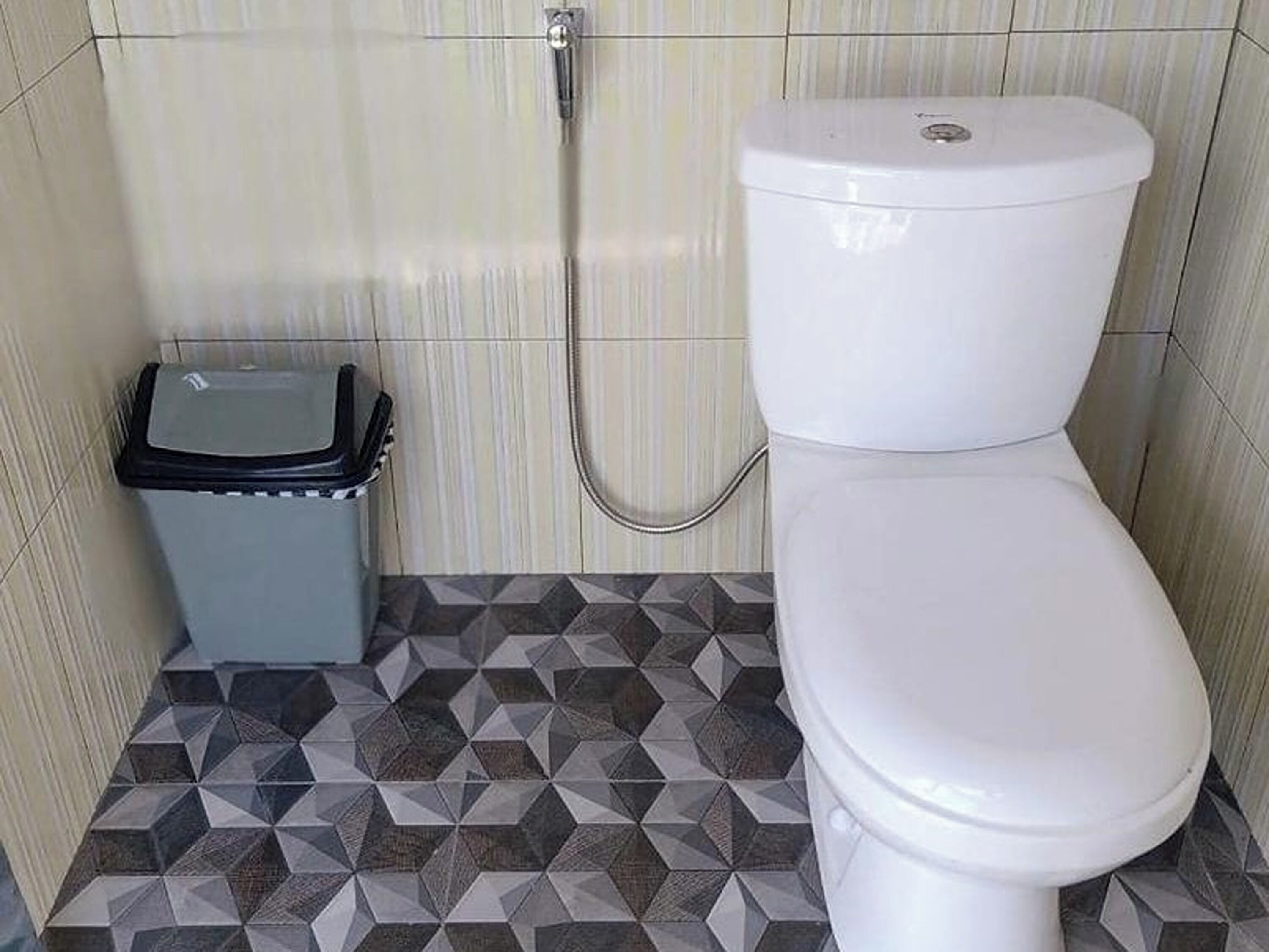 Un bagno con il water, un cestino e una doccia.