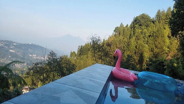 Une piscine avec un flotteur en forme de flamant rose et un anneau gonflable bleu.