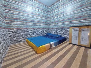 A room with a bed, a wardrobe, and a patterned wall. - Villa Zoya Montana (Megamendung)