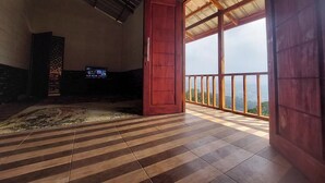 Une pièce spacieuse dotée d’une grande porte-fenêtre coulissante donnant sur un balcon avec vue.