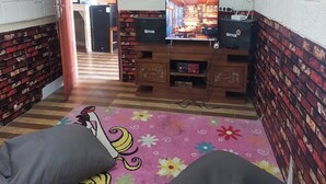 Une pièce équipée d’un téléviseur, d’enceintes et d’un tapis à motifs.