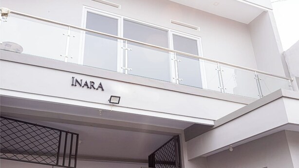 Un immeuble doté d’un balcon et dont la façade porte le nom « INARA ».