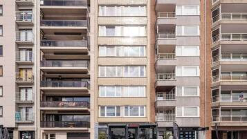 Un immeuble résidentiel à plusieurs étages, doté de balcons, d’un restaurant au rez-de-chaussée et d’une enseigne bien visible indiquant « Il Gusto ».
