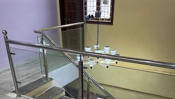 A marble staircase with glass railings and a view of the upper floor. - duplexhotel (Hyderabad)