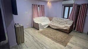 A bedroom with a bed, a TV, and a ceiling with recessed lighting. - duplexhotel (Hyderabad)