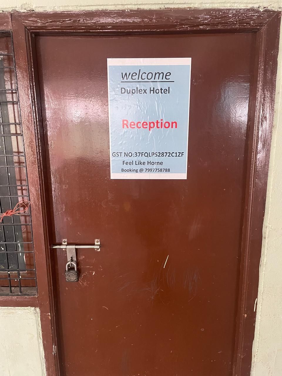 A brown hotel door with a welcome sign for Duplex Hotel Reception.