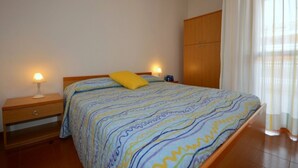 Una camera da letto con un letto, comodini, un armadio e una finestra con tende.