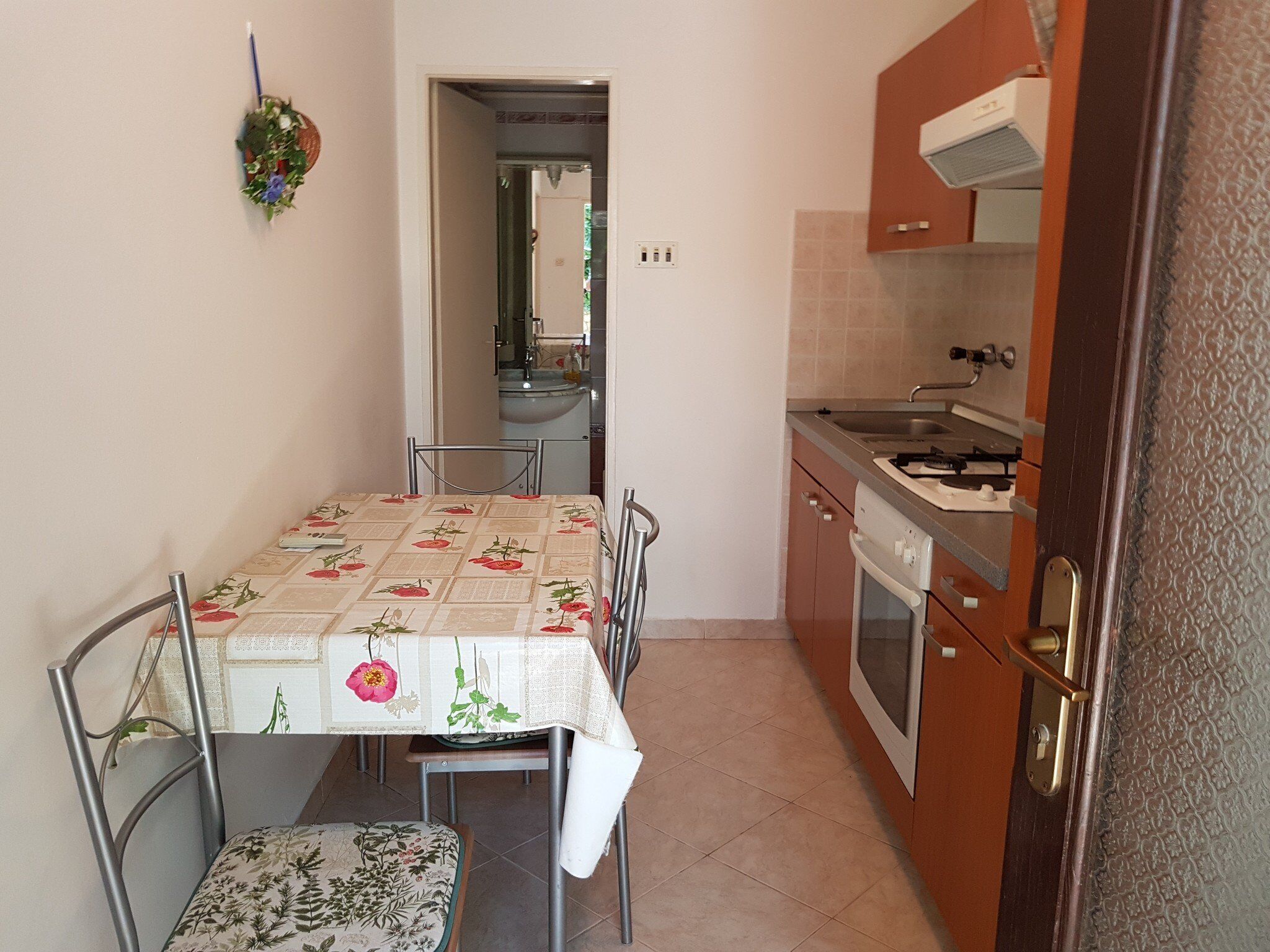 Una cocina funcional con una mesa, sillas y electrodomésticos básicos.