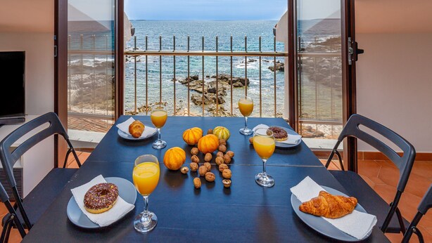 A dining table with breakfast items and a view of the sea. - Beachfront Escape in Rovinj (Rovinj)