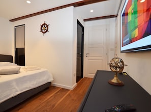 A hotel room with a bed, a desk, a globe, a TV screen, and a door. - Charming Loft Rovinj City Center (Rovinj)