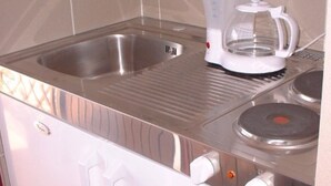 A kitchen with a stainless steel sink, a coffee maker, and a stove. - Comfortable Crikvenica Studio Apartments With Balcony (Crikvenica)