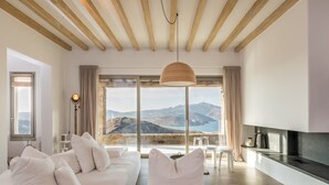 Une chambre moderne avec un grand lit, une télévision et une vue sur les montagnes.