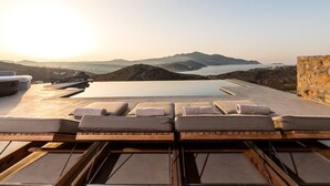 Un espace piscine aménagé sur le toit, avec des chaises longues et une vue sur le paysage environnant.