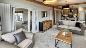 A spacious living area with a sofa, a coffee table, and a cabinet.