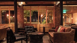 A cozy interior with leather furniture, a round coffee table, and large windows offering a view of the outdoors. - See You in the mountains (Guilin)