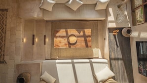 A room with a wooden floor, a woven mat, a wooden bowl, and a window with a view. - Villa Ubuntu at Bocoa Villas (Canggu)