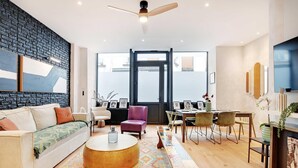 Een moderne woonkamer met een bank, salontafel en een eethoek.