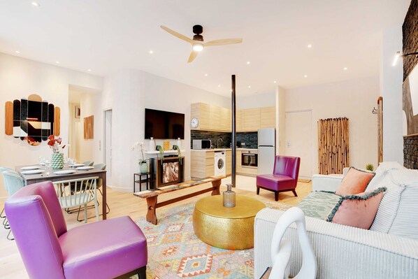 A modern living room with a sofa, chairs, a coffee table, and a dining area with a table and chairs.
