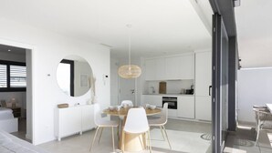 Un intérieur moderne comprenant un coin repas, une cuisine et une grande fenêtre.