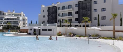 Un'area piscina con un edificio moderno sullo sfondo.