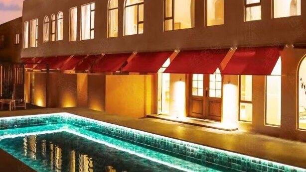 A hotel with a swimming pool, multiple windows, and red awnings. - Mila Qi Ting Li Guest House Shanghai (Shanghai)