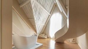 A modern bathroom with a freestanding bathtub, wooden flooring, and a sloped ceiling with skylights. - Mila Qi Ting Li Guest House Shanghai (Shanghai)