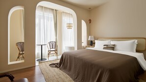 A hotel room with a large bed, a chair, a table, and a lamp. - Mila Qi Ting Li Guest House Shanghai (Shanghai)
