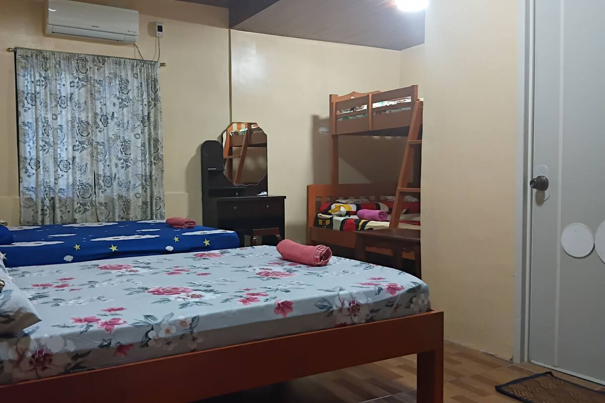 Ein Schlafzimmer mit Bett, Kommode, Spiegel und Kleiderschrank.