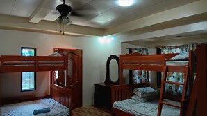 A dormitory room with two bunk beds, a ceiling fan, a window with bars, and a mirror on the wall. - Jovick Homestay (Siquijor)